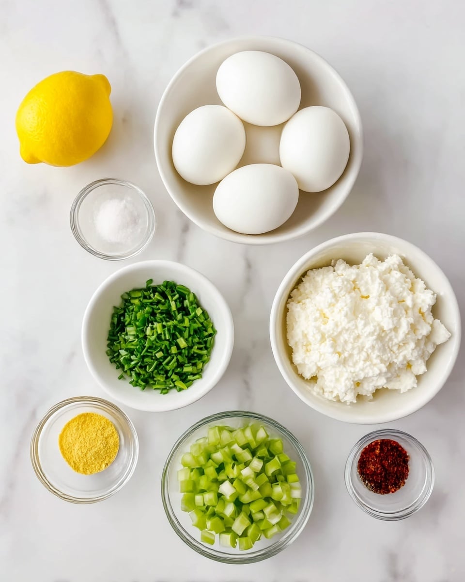 This image shows several white bowls and small glass bowls placed on a white marbled surface, each filled with different food ingredients. The largest bowl at the top center holds five smooth, white hard boiled eggs. Below it to the right is a white bowl filled with creamy white cottage cheese. To the left of the cottage cheese bowl is a white bowl of finely chopped green chives. Below that is another white bowl filled with small green diced celery pieces. At the left top corner sits a whole bright yellow lemon. Smaller glass bowls are arranged at the bottom left: one with yellow mustard, one with white salt, one with red chili flakes, and one with black pepper. The layout is neat and bright. Photo taken with an iphone --ar 4:5 --v 7