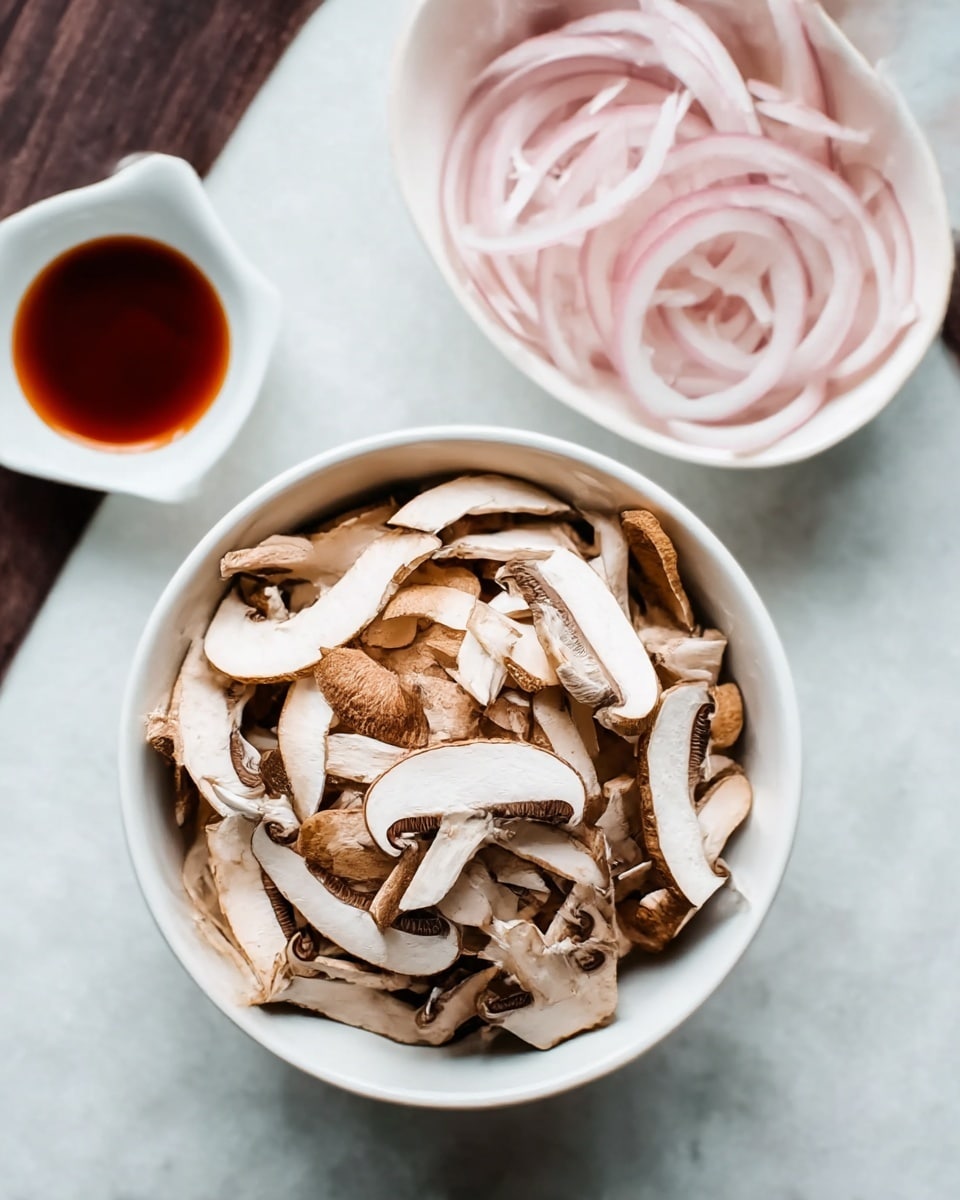 A white bowl filled with thinly sliced brown and white mushrooms sits in the center on a white marbled surface. Above and slightly to the right, a white bowl holds light pink, thin onion rings, its delicate texture visible. Above and slightly to the left of the mushroom bowl, a small white dish contains a shiny, dark reddish-brown sauce. The overall scene is simple and clean with a focus on the natural colors and layers of the ingredients. photo taken with an iphone --ar 4:5 --v 7