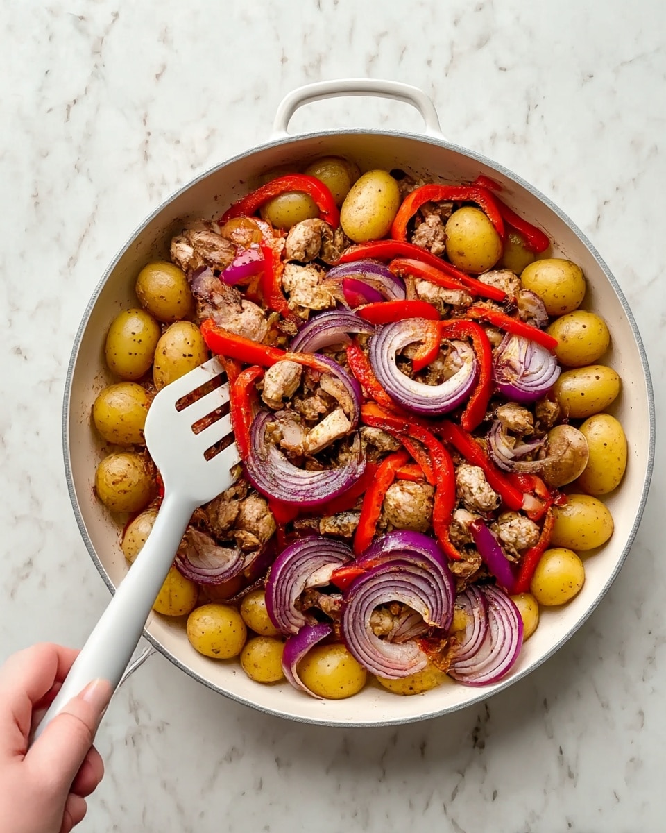 A white pan sits on a white marbled surface, filled with a colorful mixture of cooked food arranged in layers. The bottom layer shows golden-yellow small potatoes evenly spread around the pan. On top of the potatoes are pieces of browned meat, with a mix of light and dark browns, scattered evenly. Mixed throughout the meat and potatoes are thin slices of red bell peppers, adding bright red color, and slices of purple-red onion, showing curved layers. A woman’s hand holds a white-handled spatula on the left side of the pan, slightly touching the food. The whole scene is bright and clear, showing the texture and freshness of the ingredients. photo taken with an iphone --ar 4:5 --v 7