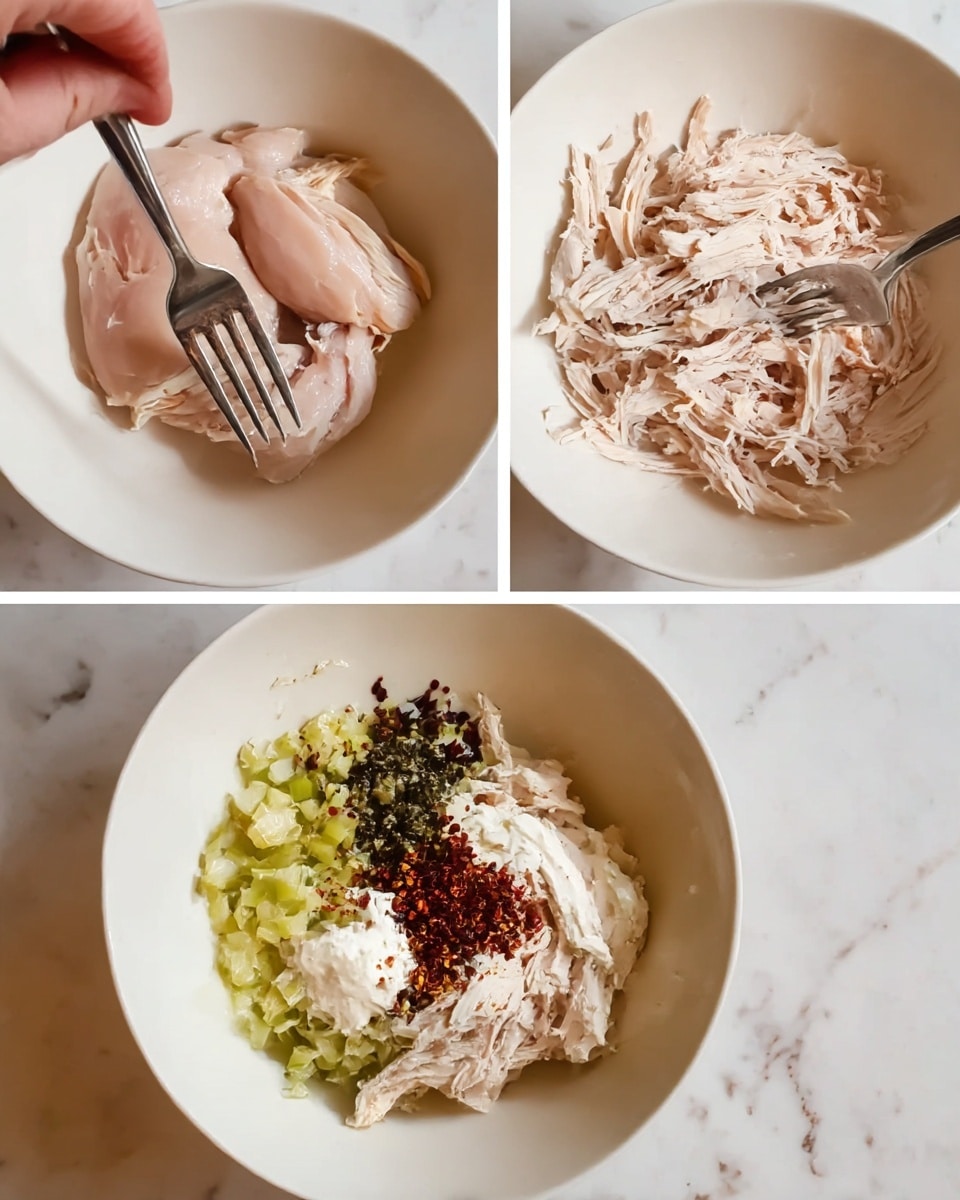 The image shows three stages of making a shredded chicken salad in a white bowl on a white marbled surface. In the first frame, two plain cooked chicken pieces with a light pinkish-white color are placed in the bowl with a woman’s hand holding a fork pressing on the chicken. The second frame shows the chicken shredded into thin, uneven light pinkish-white strips, with a fork lying on top of the shredded chicken. In the third frame, the shredded chicken fillets sit at the bottom of the bowl covered with chopped celery pieces that are light green, a dollop of creamy white mayonnaise, and a mixture of dark green herbs and red spices sprinkled on the top. The bowl is on the white marbled surface throughout the steps. photo taken with an iphone --ar 4:5 --v 7