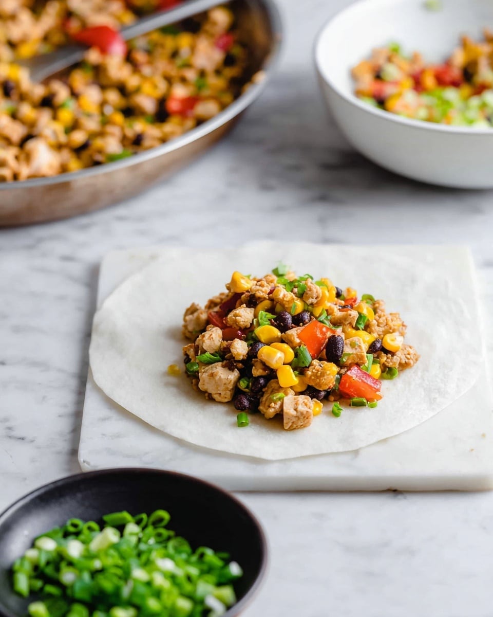 A small pile of mixed filling sits at the center of a square white wrapper on a white marbled surface. The filling consists of light brown small pieces of tofu or chicken mixed with yellow corn kernels, black beans, chopped red tomatoes, and bright green chopped onions. In the background, there is a white bowl filled with more of the same mixture, and in the foreground, a black bowl holds additional chopped green onions. The scene is brightly lit and clean. photo taken with an iphone --ar 4:5 --v 7