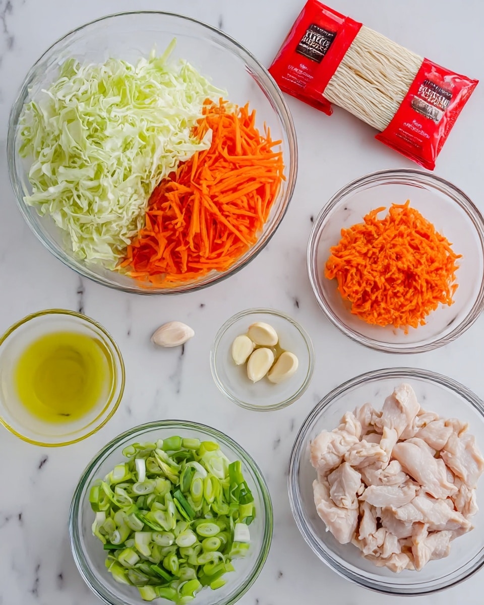 The image shows several clear glass bowls and two red-packaged noodle packs on a white marbled surface. One bowl holds finely shredded pale green cabbage, another contains bright orange julienned carrots, and a third is filled with sliced green onions. A fourth bowl is filled with raw light pink sliced chicken pieces. There is a small glass bowl with light yellow oil and two peeled garlic cloves beside it. The two red packs of dry white chow mein noodles are placed near the top center. photo taken with an iphone --ar 4:5 --v 7