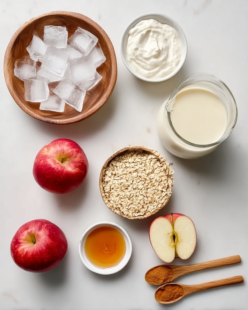 The image shows a white marble background with nine food ingredients arranged neatly. On the top left, there is a round wooden bowl filled with ice cubes. To its right, a small white bowl contains thick white yogurt, and next to it on the right, there is a clear glass jug filled with light cream. Below, in the middle row, a small white bowl holds golden honey, and another small white bowl beside it contains orange-brown vanilla extract. Next to these, a wooden bowl is filled with pale rolled oats. On the bottom left, there are two red apples with a smooth shiny skin. On the bottom right side, two wooden spoons rest on the marble, both holding light brown cinnamon powder. Photo taken with an iphone --ar 4:5 --v 7
