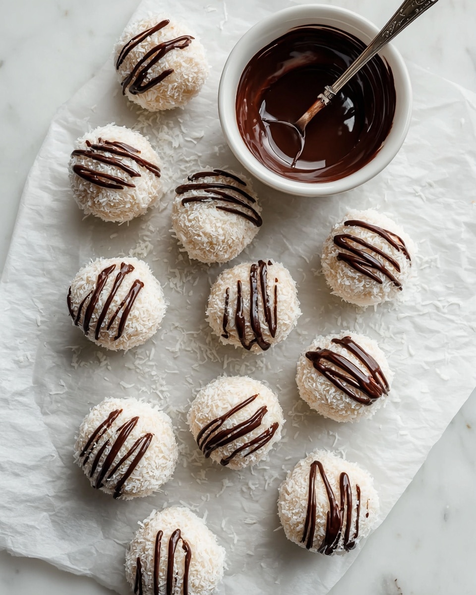 The image shows a white parchment paper with ten round coconut balls arranged in two rows. Each ball is covered in shredded coconut, giving them a textured, snowy white look. On top of each ball, there is a layer of drizzled dark chocolate in thin, curvy lines, adding a rich brown contrast. To the top right of the balls, there is a small white bowl filled with melted dark chocolate, with a metal spoon resting inside. The background is a white marbled surface, adding a clean and elegant touch. Photo taken with an iphone --ar 4:5 --v 7