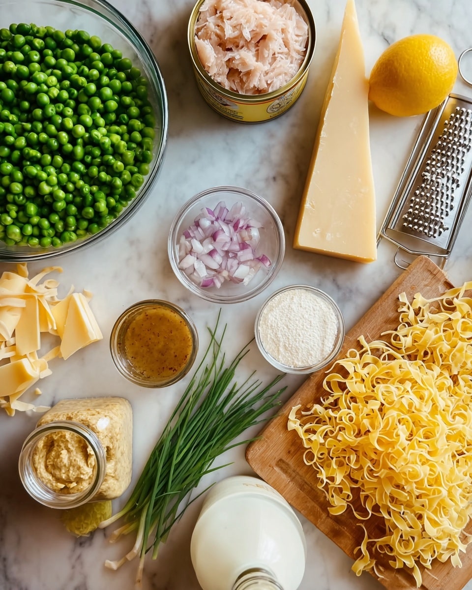 The image shows a top view of various cooking ingredients arranged on a white marbled surface. There is a large glass bowl filled with green peas in the center left, next to a small glass bowl with chopped light purple shallots. Near the bottom, there is a clear glass jar with a yellow-brown mustard-like sauce and a small bowl with white flour. To the right, there is a pile of uncooked yellow egg noodles scattered loosely. Above the noodles, a can of light pink tuna with an open lid is visible beside some green chives laying flat. At the top right, a yellow lemon sits on the white marbled surface beside a wooden cutting board holding a metal cheese grater and shredded pale yellow cheese. A block of solid pale yellow cheese rests next to the shredded cheese on the board. A glass bottle with a white lid filled with clear liquid stands near the center bottom. photo taken with an iphone --ar 4:5 --v 7