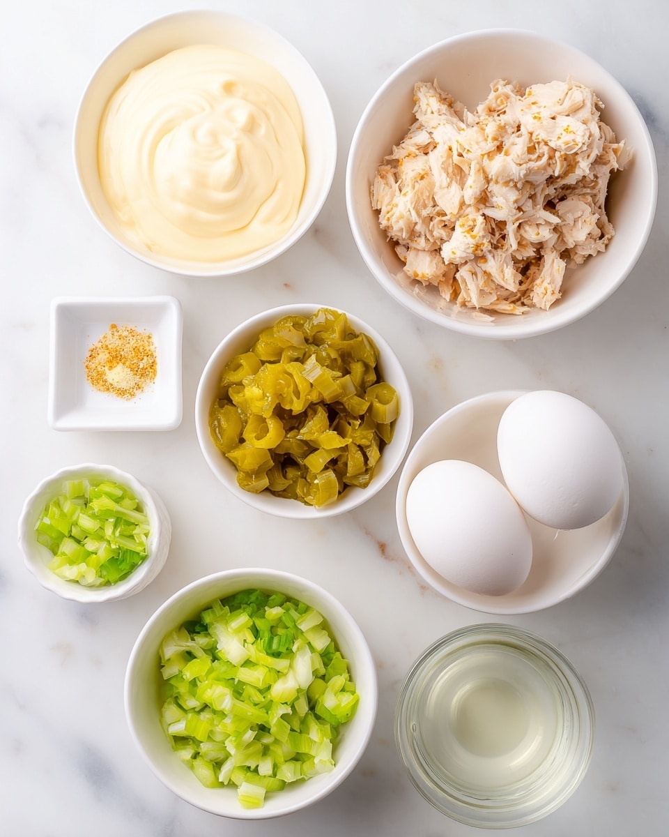 The image shows six small white bowls arranged on a white marbled surface, each containing different ingredients: the top right bowl is filled with shredded cooked chicken pieces that are light brown with some darker seasoning spots; the top left bowl holds creamy, pale yellow mayonnaise with a smooth texture; the middle right bowl contains two whole, smooth, white boiled eggs; the middle left bowl has bright yellow-green chopped pickles with a moist look; the bottom right bowl holds a small amount of clear liquid, likely vinegar; the bottom left bowl contains finely chopped green celery along with a small white square dish with salt and a yellow seasoning powder. Photo taken with an iphone --ar 4:5 --v 7