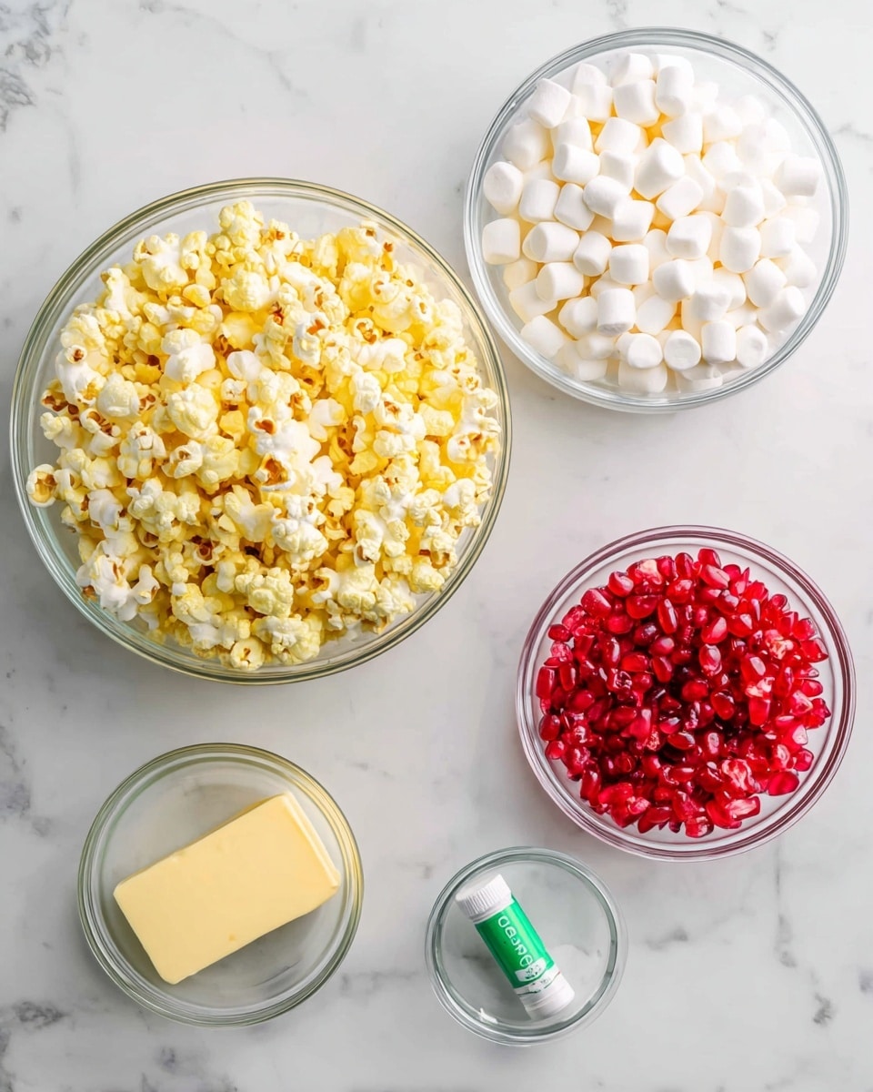 A top view of four clear glass bowls and a green tube on a white marbled surface. The largest bowl at the bottom center is filled with yellow and white popcorn. Above it, a large bowl holds many small white marshmallows. To the right of the marshmallows, a small bowl contains many red candy pieces. Below the red candies, there is a smaller bowl with a block of light yellow butter. Next to the butter, a small green and white tube is placed on the surface. Photo taken with an iphone --ar 4:5 --v 7