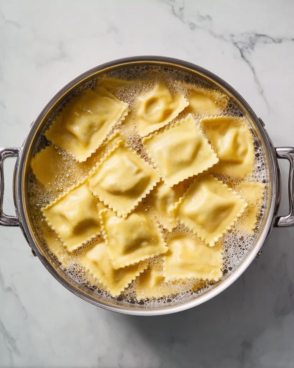 A metal pot filled with large square ravioli cooking in bubbling water. The ravioli are a light yellow color with slightly ruffled edges. The pot handles are visible on both sides, and the pot sits on a white marbled surface. The water is clear with some foam on the top. Photo taken with an iphone --ar 4:5 --v 7