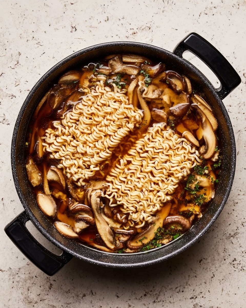 A round black pot filled with a dark brown broth, inside are three blocks of wavy, uncooked instant noodles floating near the top. Scattered throughout the broth are many light brown and white sliced mushrooms, as well as small bits of green herbs. The pot rests on a white marbled surface with black handles on each side. photo taken with an iphone --ar 4:5 --v 7