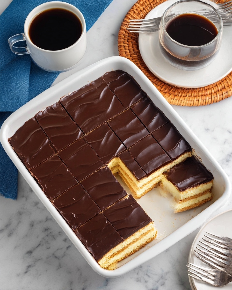 The image shows a rectangular white dish filled with a layered dessert that has been partially eaten, revealing three main layers inside. The bottom two layers are light yellow cream separated by thin brown biscuit or cookie layers, while the top layer is a smooth, thick dark chocolate glaze with slight waves on its surface. The dessert is cut into 12 neat squares, with one missing square showing the creamy texture inside. The dish sits on a white marbled surface, surrounded by a white cup of black coffee on a wooden coaster with a rattan top, a glass cup of black coffee also on a coaster, a blue cloth, and a white plate holding three forks. Photo taken with an iphone --ar 4:5 --v 7