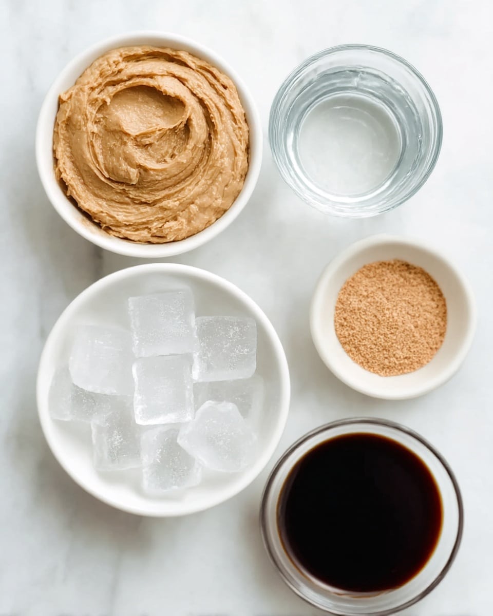 The image shows five white bowls arranged on a white marbled surface. The largest bowl in the top left corner contains a thick, creamy tan paste with a slightly rough texture and swirling pattern. Below it is a bowl filled with clear ice cubes, which have sharp edges and a glossy look. To the right of the ice cubes is a smaller bowl holding a fine, light brown powder spread in a thin, even layer. Above this powder bowl is another medium-sized bowl filled with a dark liquid, almost black with a glossy surface that shows slight reflections. Finally, a small clear glass bowl at the top holds a transparent liquid, looking like water with a smooth surface. Photo taken with an iphone --ar 4:5 --v 7