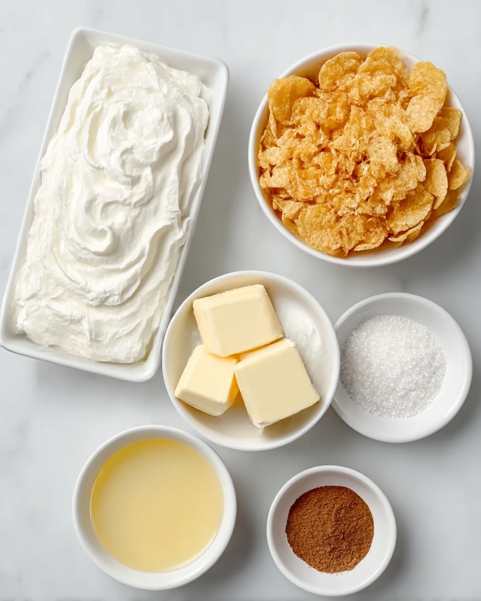 The image shows seven white bowls and dishes arranged on a white marbled surface. The largest dish is rectangular and filled with a thick white whipped cream texture, appearing dense and fluffy on top. Next to it, a smaller bowl holds a similar whipped cream but in a swirl pattern. Another bowl contains three pale yellow butter cubes with smooth flat sides. There is a round bowl filled with golden, crispy cornflakes with a rough texture. A smaller round bowl contains a pale yellow liquid, smooth and shiny. Two tiny bowls hold finely ground brown cinnamon powder, soft and powdery, and granulated white sugar, with a sparkling grainy texture. The layout is neat and organized, all on a clean white marbled background. photo taken with an iphone --ar 4:5 --v 7