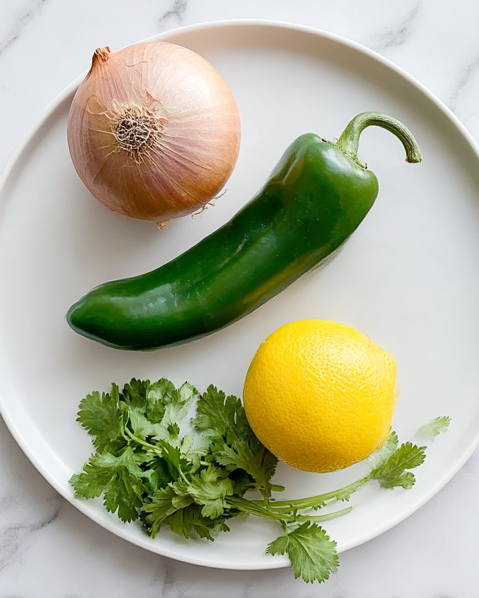 A white plate holds four fresh ingredients neatly spaced across its surface on a white marbled background: a light brown shallot with a papery outer layer on the left, a shiny, smooth green pepper with a slight curve next to it, a bright yellow lemon with a slightly textured skin on the right, and a small bunch of fresh green cilantro leaves at the bottom. The colors are vibrant and the textures vary from smooth to leafy. photo taken with an iphone --ar 4:5 --v 7