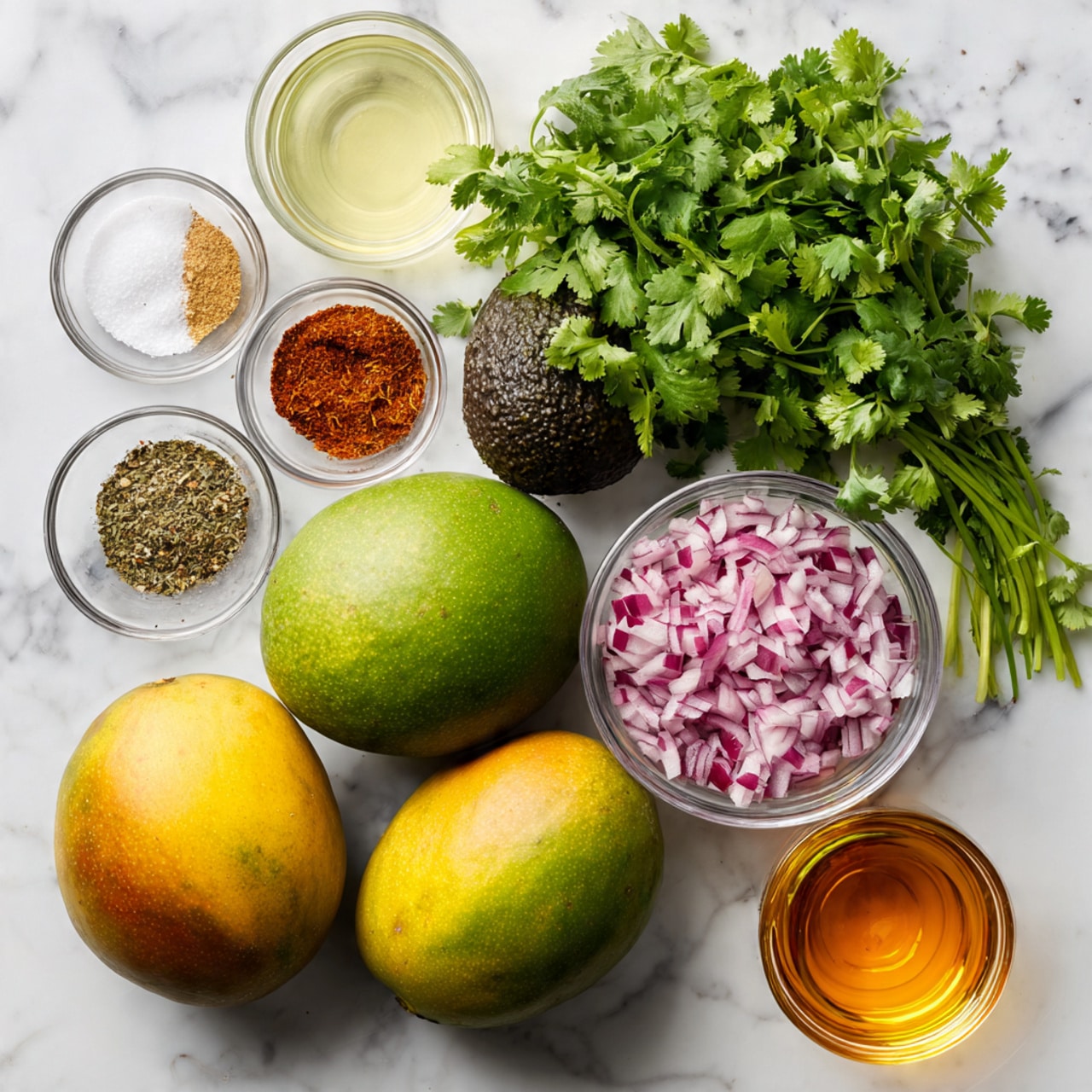 The image shows fresh ingredients for a dish arranged on a white marbled surface. There are two large greenish-yellow mangoes with a bit of reddish tint and one dark green avocado with a rough texture placed near each other in the center. Above them, there is a bunch of bright green cilantro leaves in a small clear bowl. To the right, there is a clear bowl filled with finely chopped red onions and another small bowl with a brown spice powder. On the left side, there are three small bowls: one with a mixture of salt, black pepper, and red chili powder, one with a white liquid, and lastly a bottle of clear yellow oil. At the bottom right, a small clear bowl holds amber honey. The photo taken with an iphone --ar 4:5 --v 7